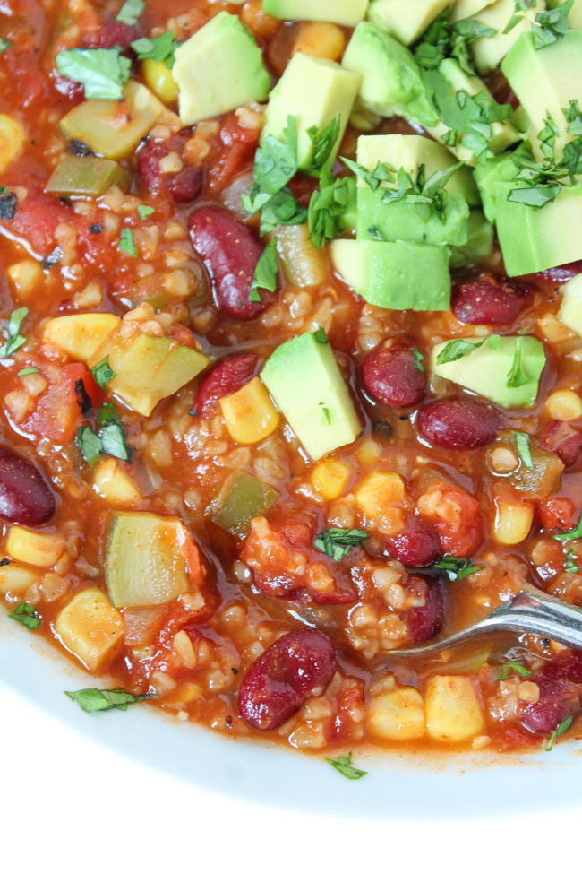 Close-up view of bulgur chili in a white bowl with spoon