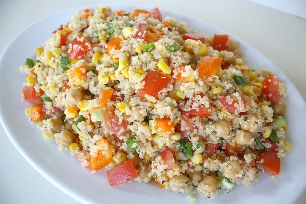 Quinoa Vegetable Salad tossed with lemon-basil dressing on a plate