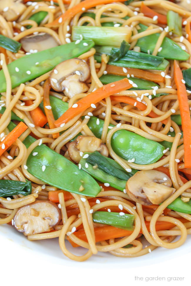 Bowl of vegan pasta with snow peas, mushroom, and carrot