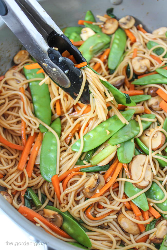 Asian garlic spaghetti with snow peas, mushrooms, carrots in a pan