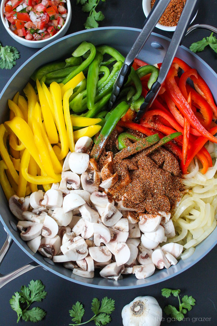 Preparing fajita ingredients in a large pan before cooking