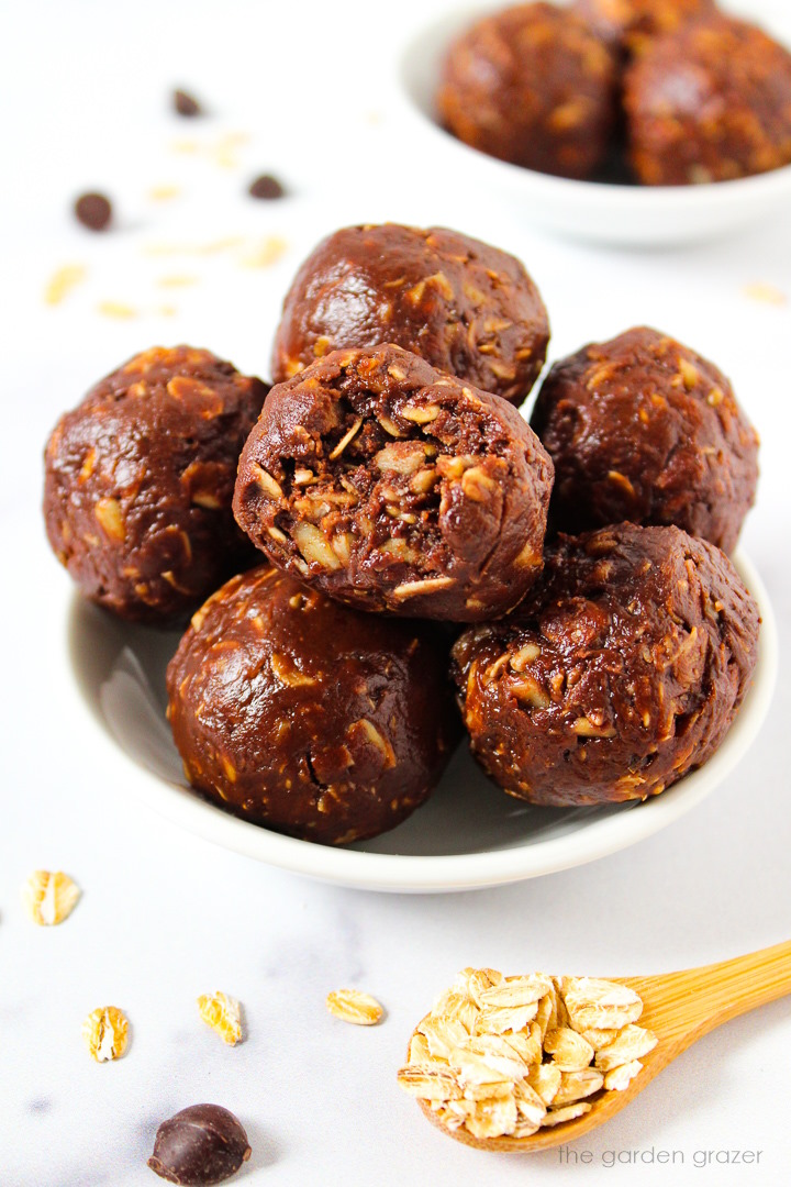 Chocolate oat balls with peanut butter stacked together in a white serving bowl