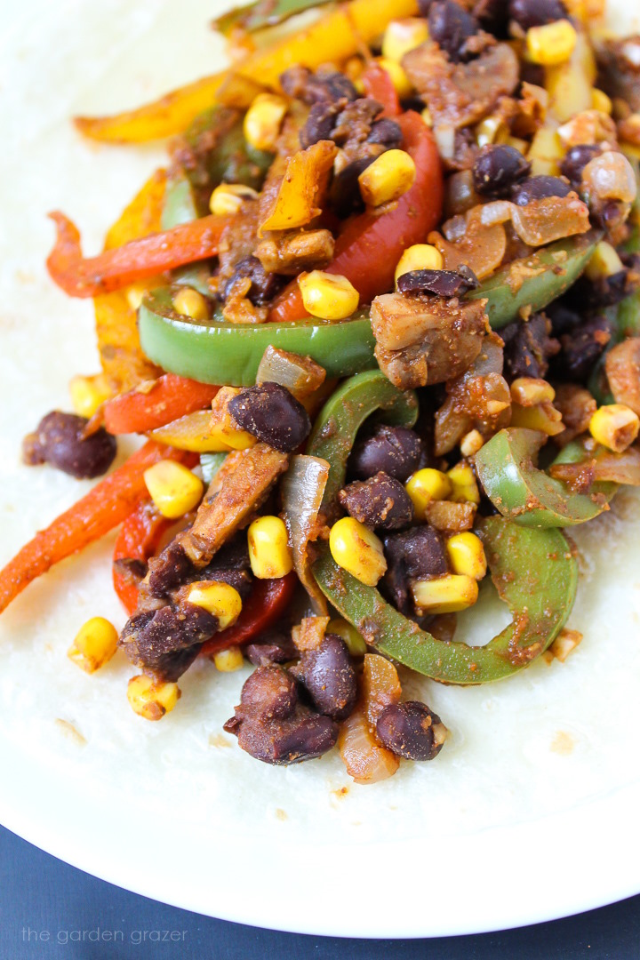 Close up view of an open-faced corn and black bean fajita on a tortilla