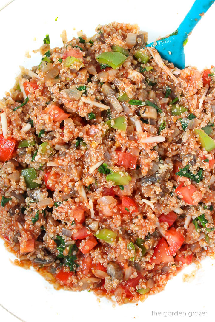 Vegan casserole mixture in a glass bowl with stirring spatula