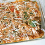 Vegan pizza quinoa casserole in a large glass baking dish with spoon