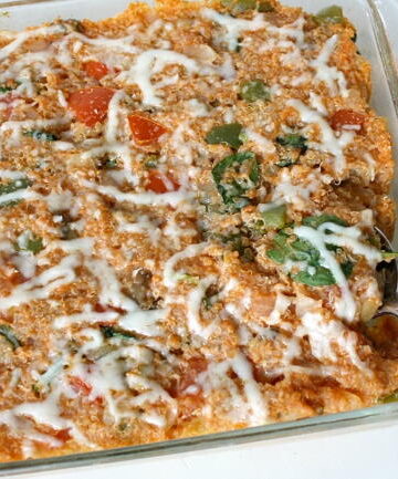 Vegan pizza quinoa casserole in a large glass baking dish with spoon