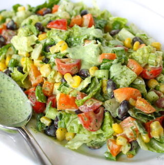 Chopped Salad tossed with creamy dressing on a plate with spoon