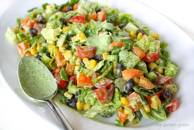 Chopped Salad tossed with creamy dressing on a plate with spoon