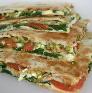 Vegan pesto quesadillas with tomato and spinach cut in half