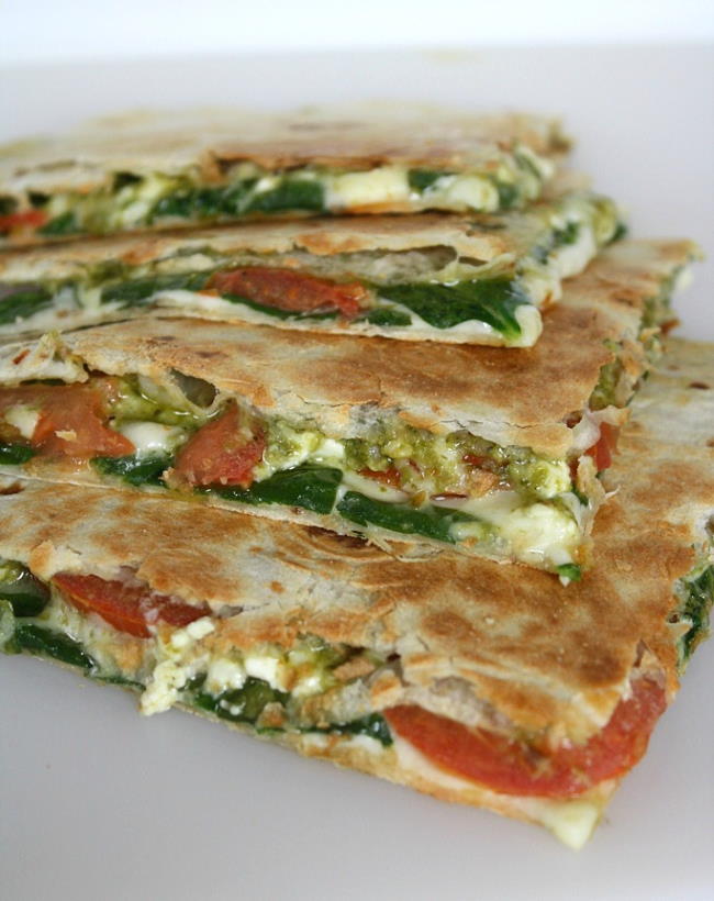 Vegan pesto quesadillas with tomato and spinach cut in half