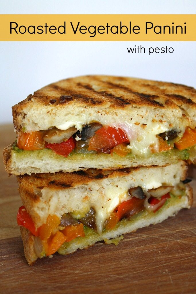 Two halves of roasted vegetable panini stacked on a cutting board
