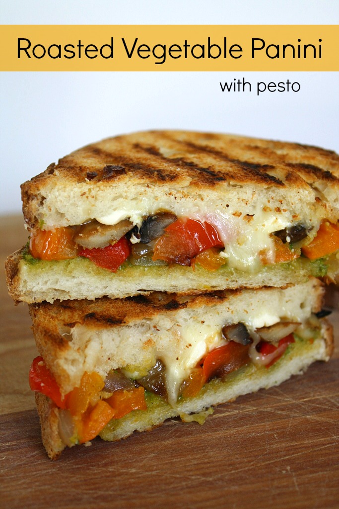 Two halves of roasted vegetable panini stacked on a cutting board