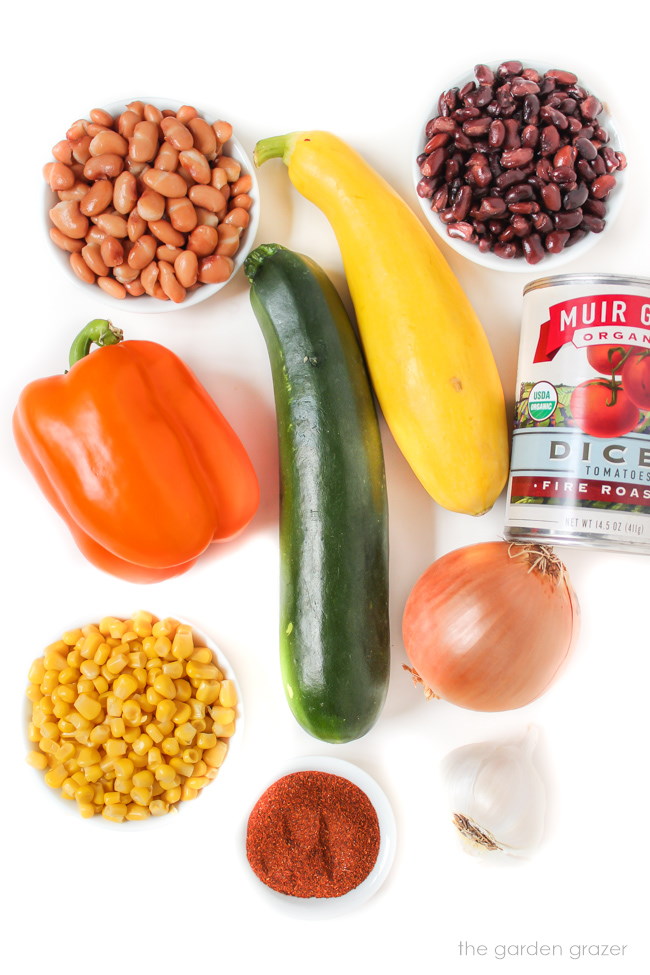 Beans and fresh vegetable ingredients on a white table