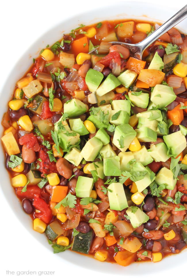 Vegan summer vegetable chili in a bowl with spoon