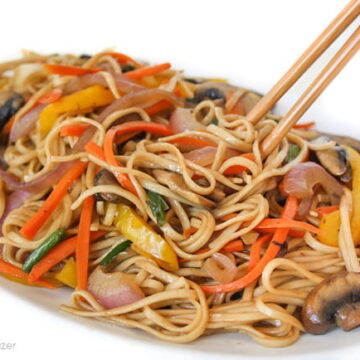 Vegan vegetable lo mein on a plate with chopsticks