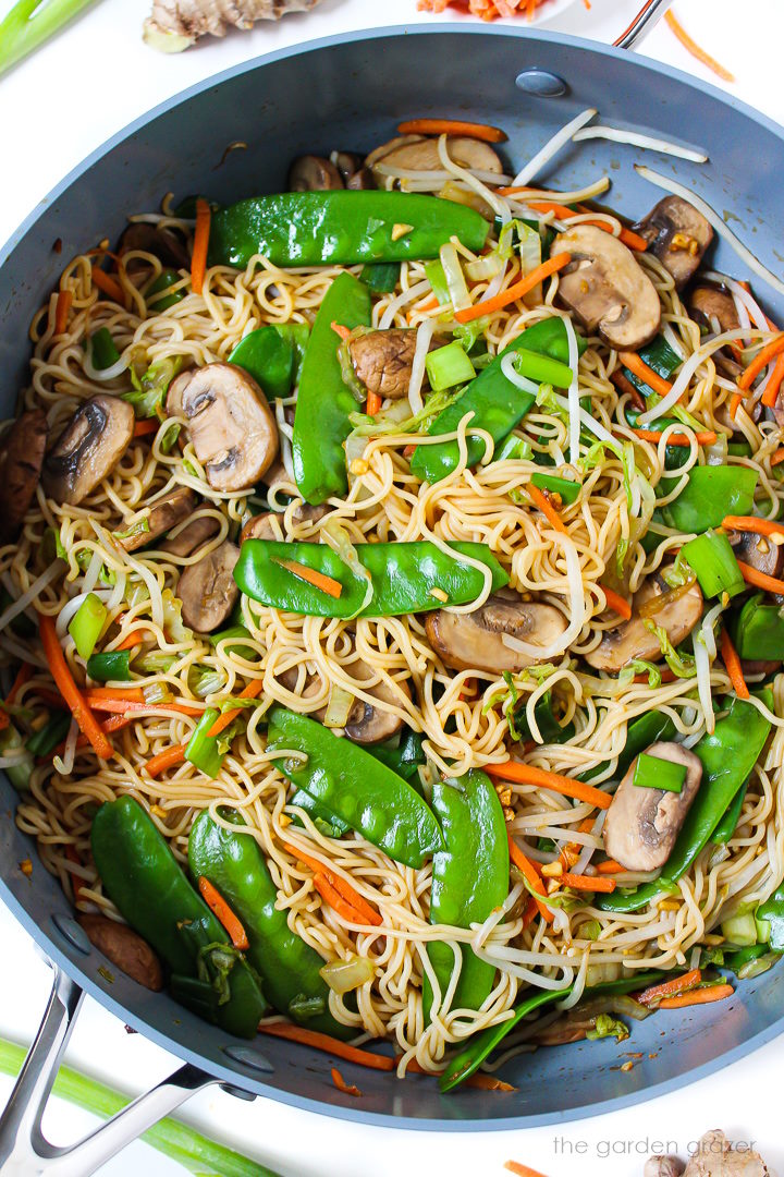 Overhead view of vegan vegetable lo mein cooking in a large skillet