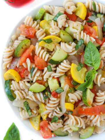 Bowl of fresh garden vegetable pasta with basil