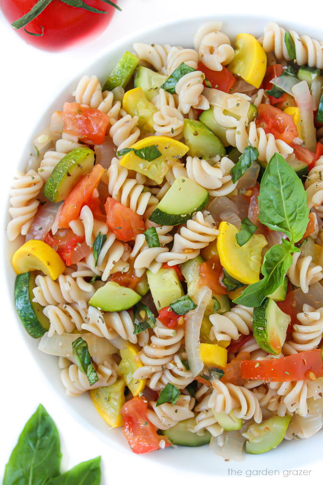 Bowl of fresh garden vegetable pasta with basil