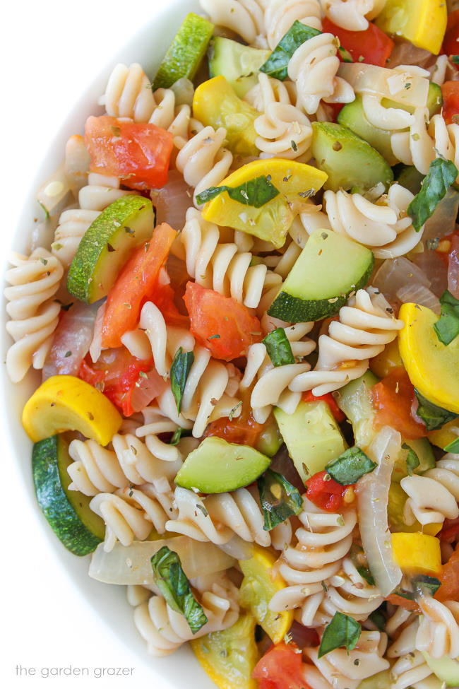 Vegan garden vegetable pasta in a bowl with basil