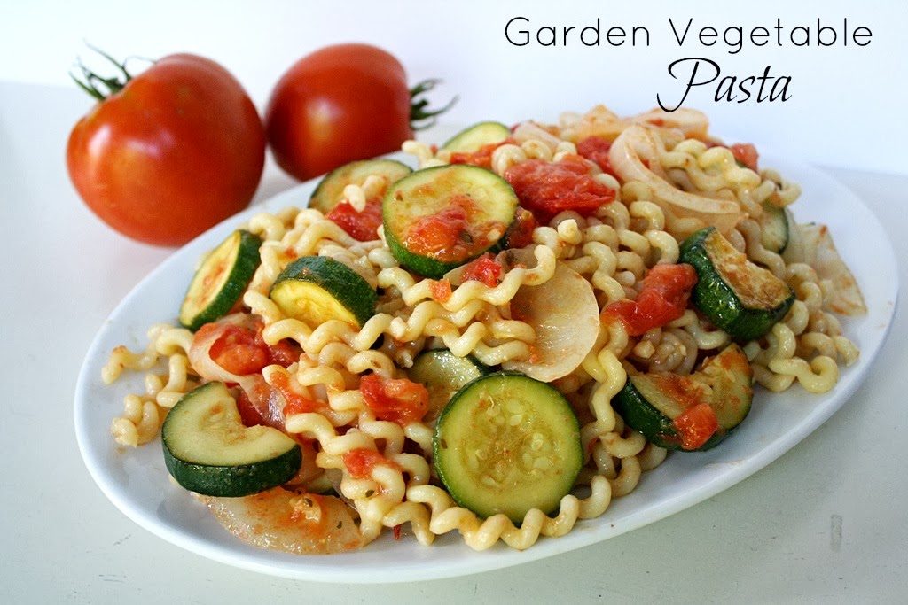 Vegan garden vegetable pasta on a plate with tomatoes