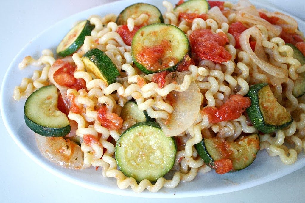Plate with garden vegetable pasta with zucchini and tomato