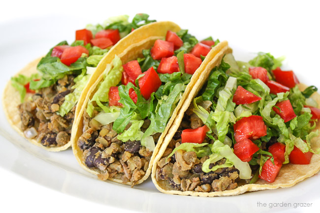 Three black bean and lentil tacos on a plate