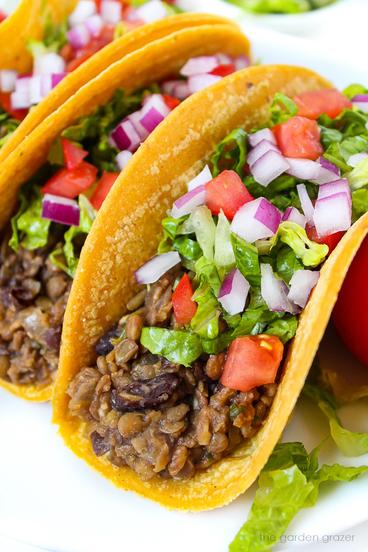 Close up view of black bean lentil tacos on a white plate