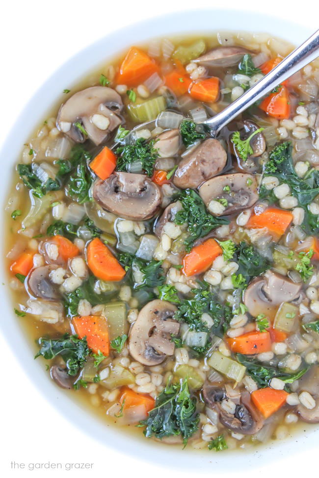 Bowl of vegan mushroom barley soup with kale