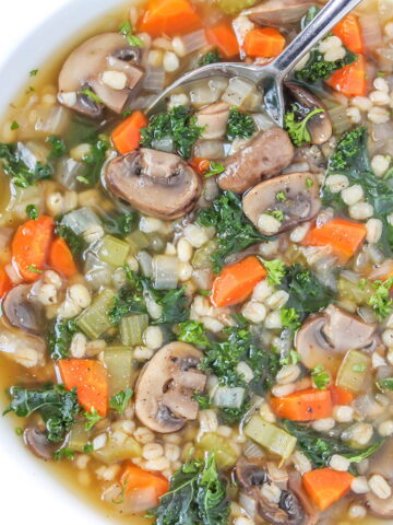 Mushroom barley kale soup in a white bowl