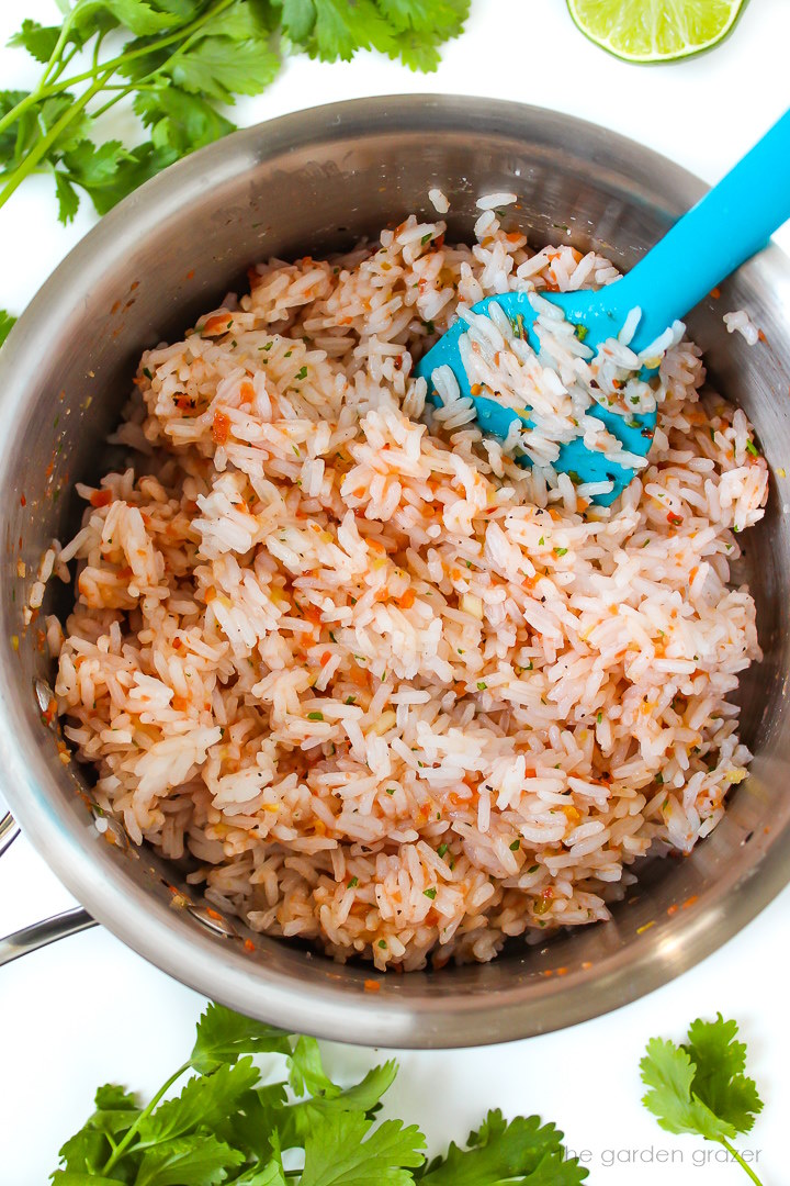 Overhead view of preparing cooked rice with salsa in a small pot
