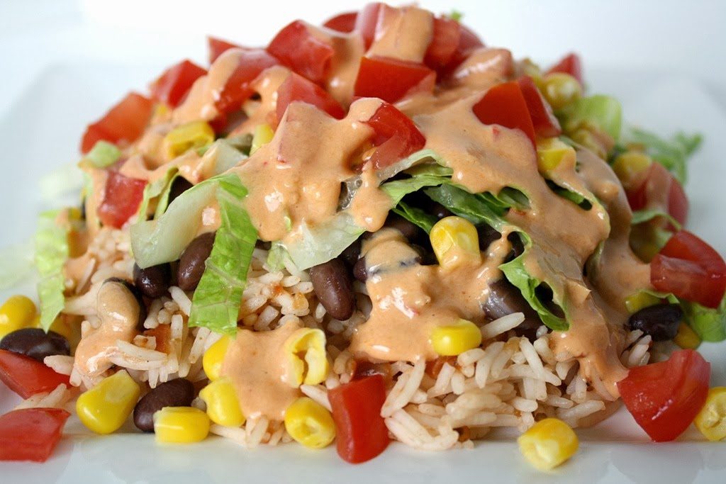 Vegan burrito bowl topped with chipotle sauce on a plate