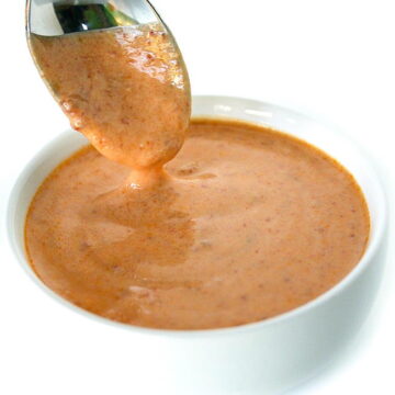 Spoon dipping into a small bowl of creamy chipotle sauce