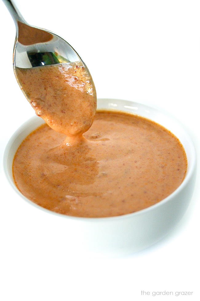 Spoon dipping into a bowl of vegan creamy chipotle sauce