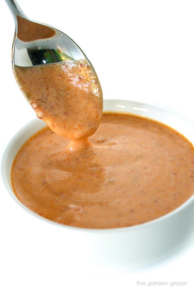 Spicy pepper sauce in a small bowl with spoon