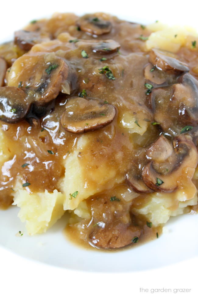 Mashed potatoes on a white plate with vegan mushroom gravy on top