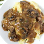 Vegan gravy over mashed potatoes on a white plate