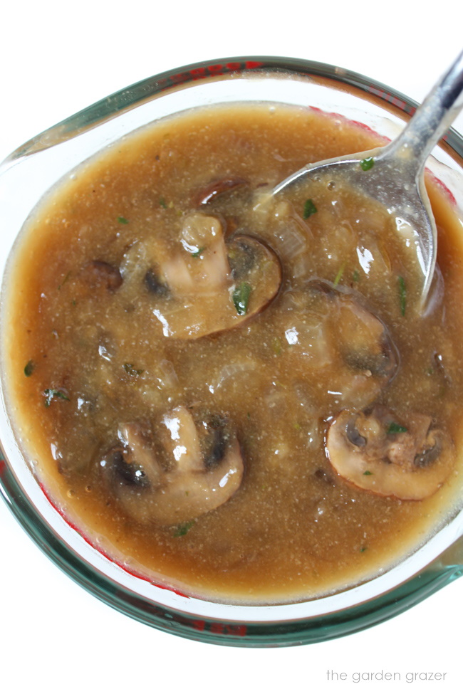 Mushroom gravy in a serving cup with spoon