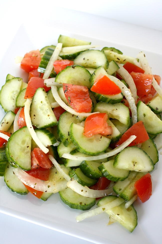Plate of cucumber tomato salad with onion and tangy vinegar dressing