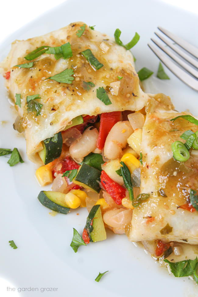 White bean zucchini enchiladas on a plate with fork