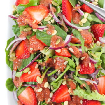 Plate of strawberry spinach salad with tomato balsamic dressing