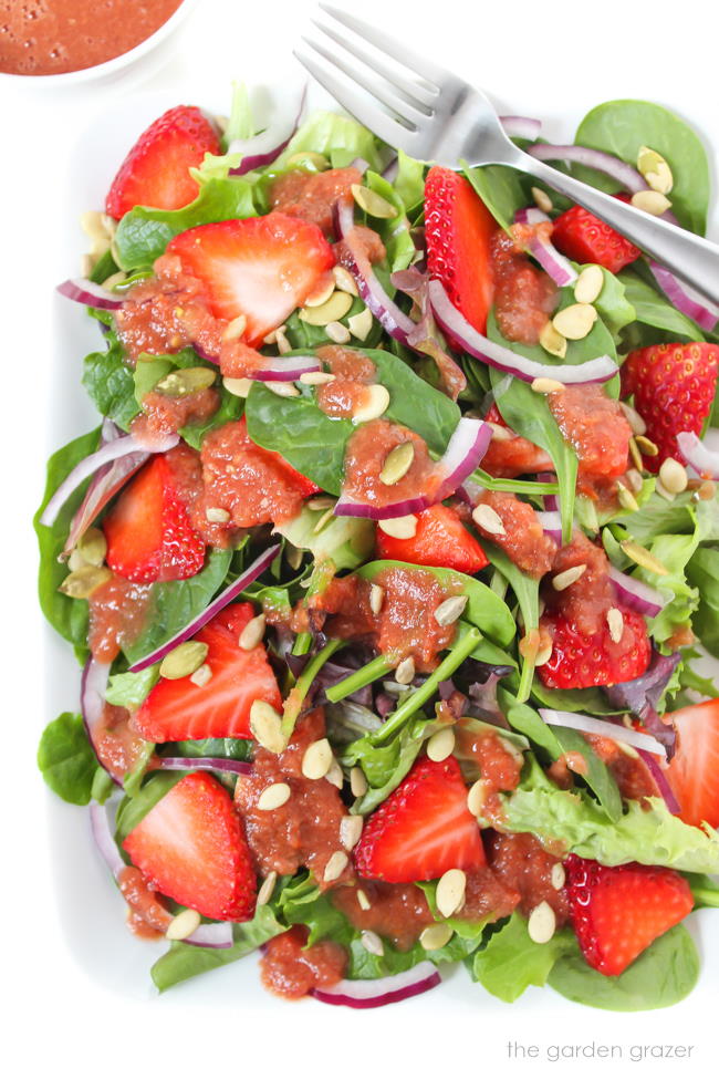 Plate of strawberry spinach salad with tomato balsamic dressing