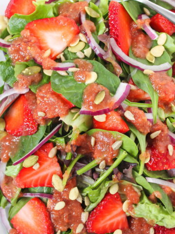 Strawberry spinach balsamic salad on a white plate
