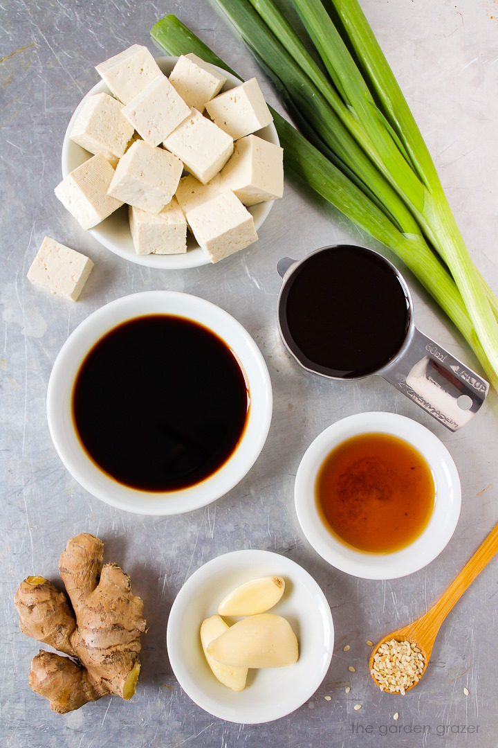 Green onions, tamari, hoisin sauce, sesame oil, and seasoning ingredients laid out on a metal tray