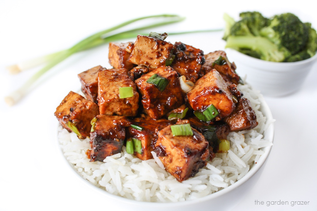 Asian Garlic Tofu in a bowl with white rice and green onions