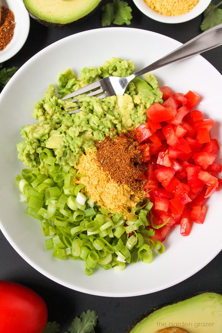 Preparing ingredients for quesadilla filling in a small white bowl before mixing together