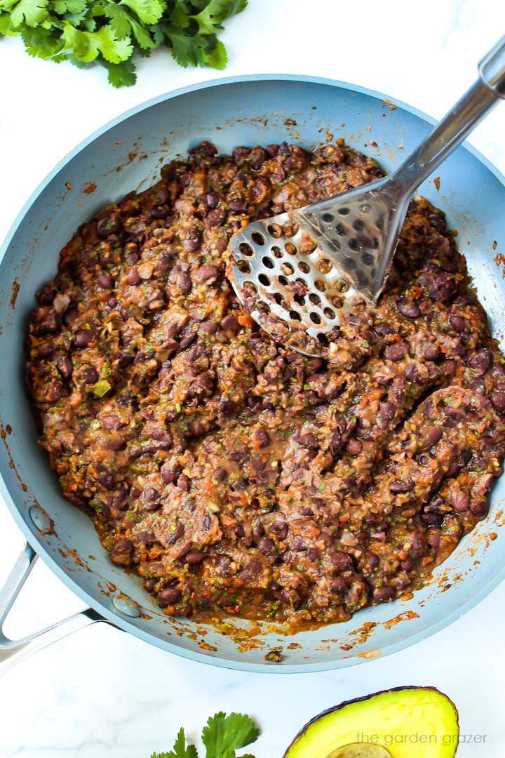 Black bean taco mixture mashed together in a skillet as it cooks