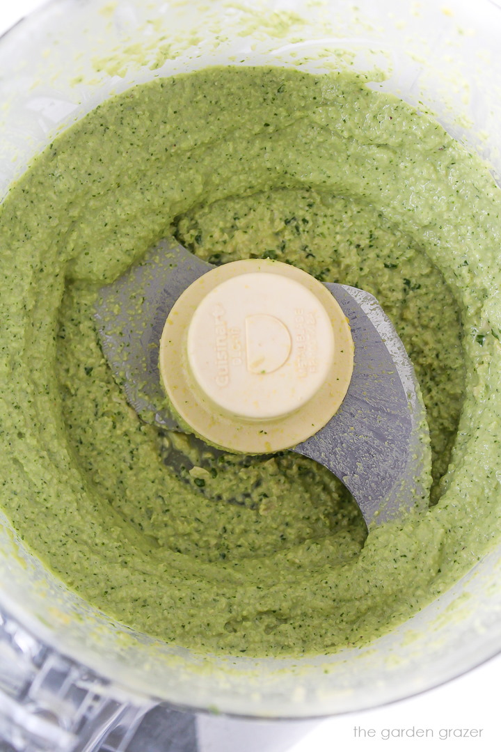 Overhead view of vegan cashew basil pesto blended in a food processor