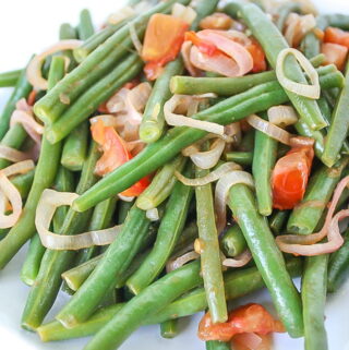 Plate of green beans with tomato and shallot