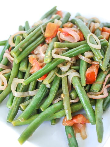 Plate of green beans with tomato and shallot