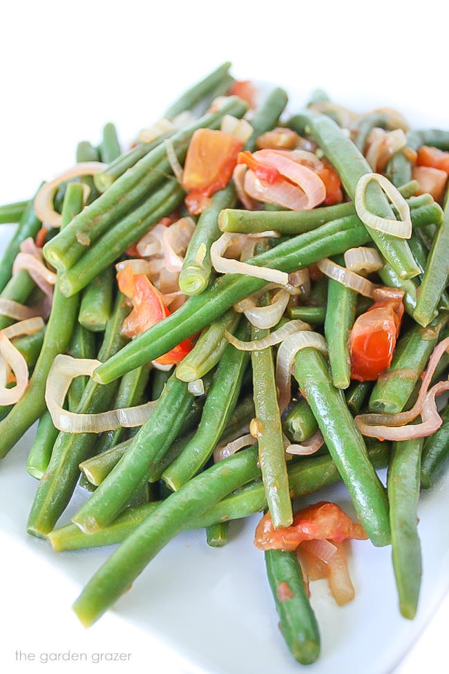 Plate of green beans with tomato and shallot